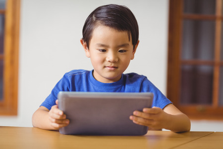 Cute pupil in class using tablet pc at the elementary school