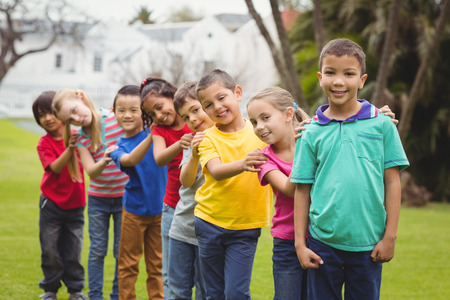 Cute pupils smiling at camera outside on elementary school campus
