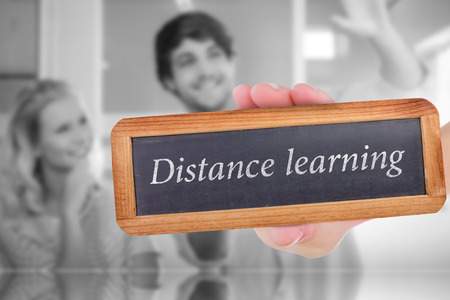 The word distance learning and hand showing chalkboard against colleagues envisioning an idea...