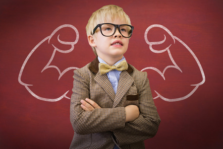 Cute pupil dressed up as teacher  against deskの写真素材