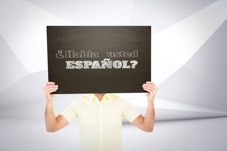 Casual man showing board against abstract white roomの写真素材