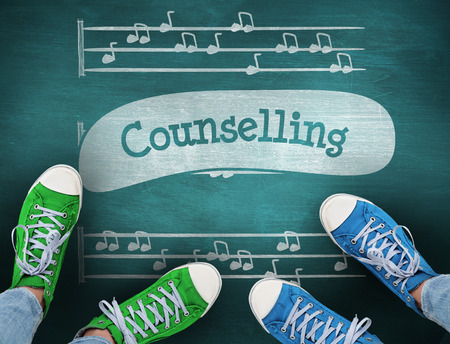 The word counselling and casual shoes against green chalkboardの写真素材