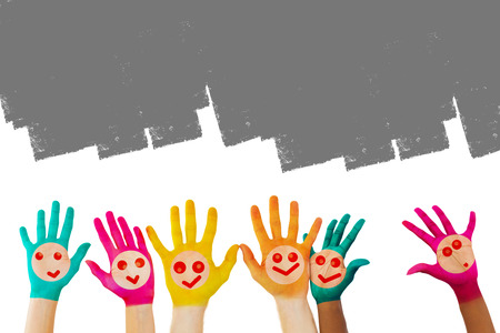 Hands with colourful smiley faces against grey vignetteの写真素材