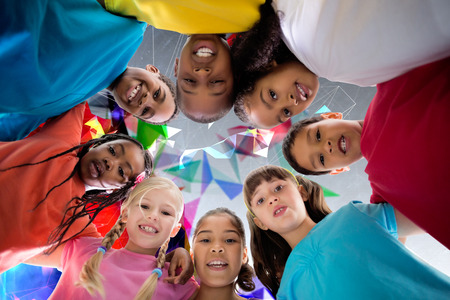 Elementary pupils smiling against geometric designの写真素材