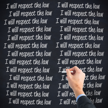 Hand writing with a white chalk against blackboardの写真素材