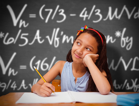 Cute pupil at desk against black backgroundの写真素材