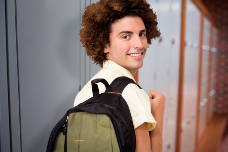 Casual young man in office corridor against closed lockers in a row at the college