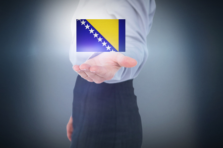 Businesswoman presenting with hand against blue backgroundの写真素材