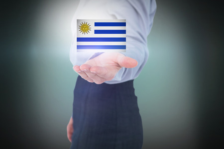 Businesswoman presenting with hand against green background with vignetteの写真素材