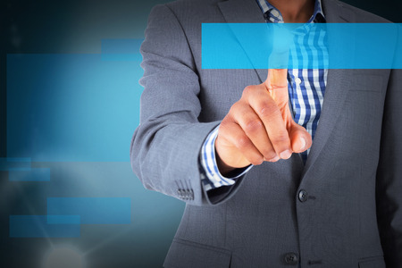 Focused businessman pointing against blue backgroundの写真素材