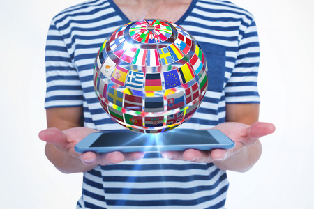 Close up of man holding tablet against sphere made of flags