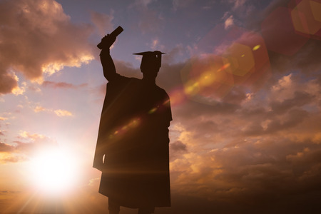Silhouette of graduate against sun shiningの写真素材