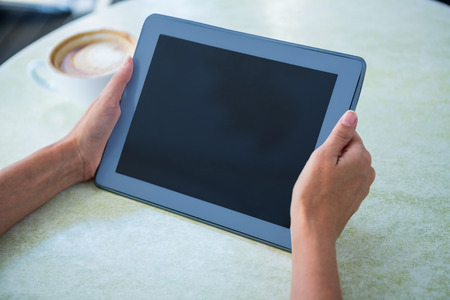 Woman using tablet on cafe terrace on a sunny dayの写真素材
