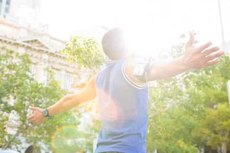 Carefree athlete with arms outstretched in the cityの写真素材