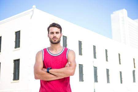 Portrait of a focus athlete with arms folded on a sunny dayの写真素材