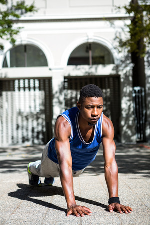 Happy athlete doing push-ups on the street