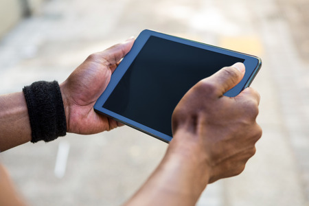 Athletic man using tablet computer in the city