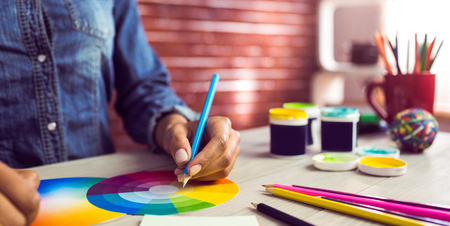 Graphic designer drawing on colour chart at workplace Graphic designer drawing on colour chart at workplace