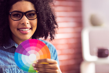 Casual businesswoman holding a color wheel in her officeの写真素材