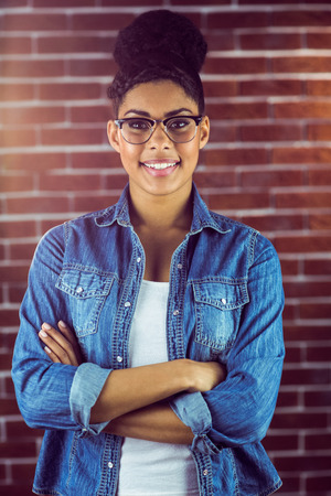 Portrait of a gorgeous hipster posing with glasses against red brick backgroundの写真素材