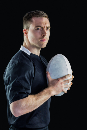 Side view of a rugby player holding a rugby ballの写真素材