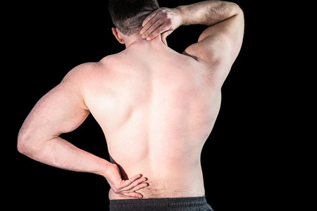Strong bodybuilder with painful back and neck on black backgroundの写真素材