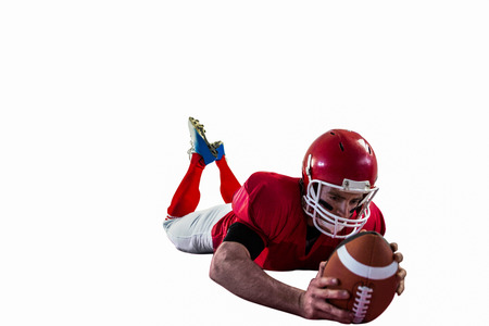 American football player reaching football on american football fieldの写真素材