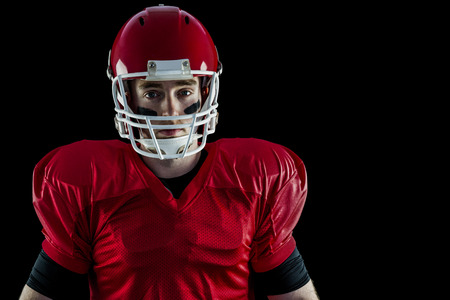 Portrait of american football player wearing his helmet against black backgroundの写真素材