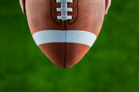 Close up view of upheld football on american football fieldの写真素材