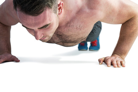 Strong bodybuilder doing press up on white background