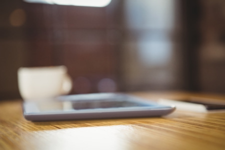 Close-up of digital tablet and coffee on table in the coffee shopの写真素材
