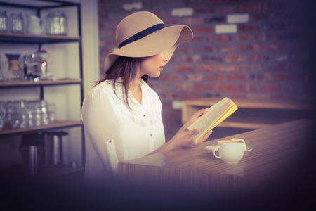 Beautiful businesswoman reading a book outside at the coffee shop