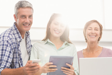Portrait of casual business people with electronic devices in the office