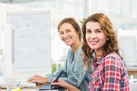 Casual businesswomen looking at computer in an officeの写真素材