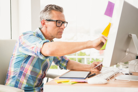 Casual designer working with computer in the officeの写真素材