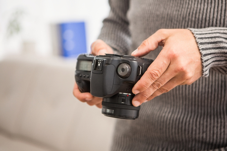 Close up view of hands holding camera in the officeの写真素材
