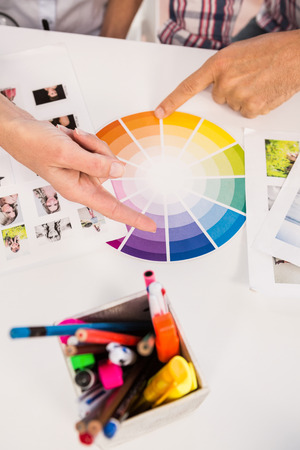 Casual designers working with colour chart and photographs in the officeの写真素材