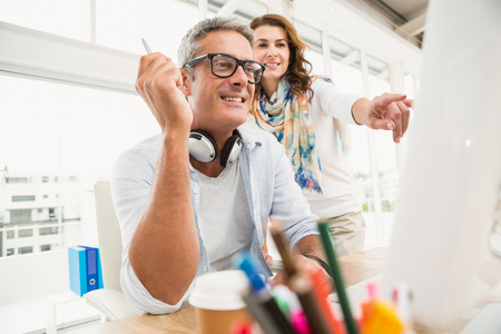 Two casual designers working with computer in the officeの写真素材