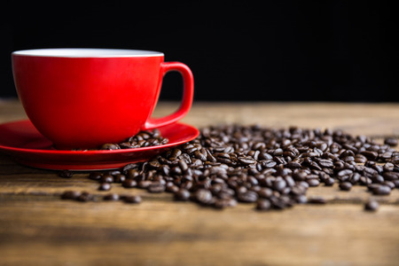 Coffee beans on a table with cup shot in studioの写真素材