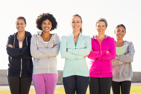 Portrait of smiling sporty women with arms crossed in parklandの写真素材