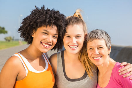 Portrait of sporty women smiling at camera at promenadeの写真素材