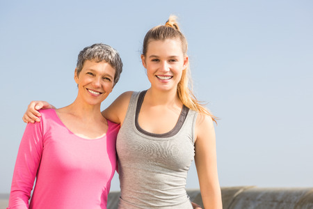 Portrait of sporty mother and daughter smiling at promenadeの写真素材