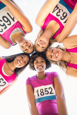 Portrait of five smiling runners supporting breast cancer marathon in parklandの写真素材
