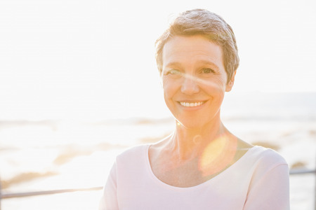 Portrait of smiling sporty woman at promenade on a sunny dayの写真素材