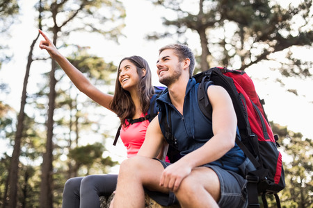 Young happy joggers sitting on rock and looking away in the natureの写真素材