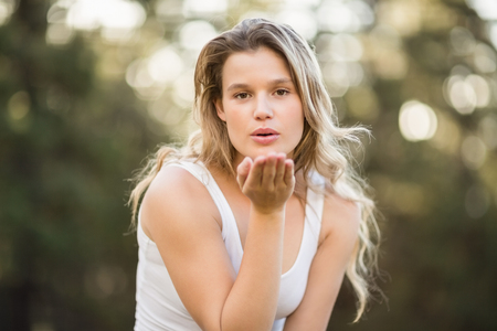 Pretty young jogger blowing kiss in the natureの写真素材