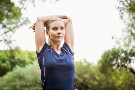 Serious athletic woman doing arms stretching
