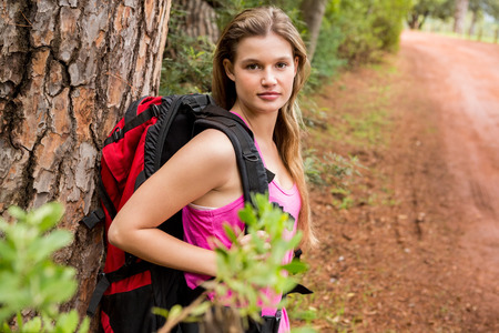 Pretty blonde hiker with backpack in the nature