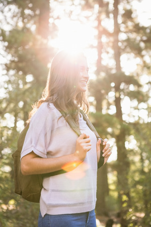Pretty brunette hiker holding rucksack in the natureの写真素材