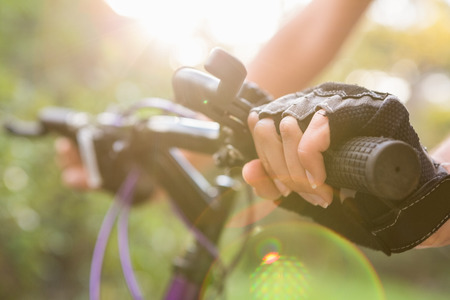 Woman mountain biking and holding handlebars in the natureの写真素材